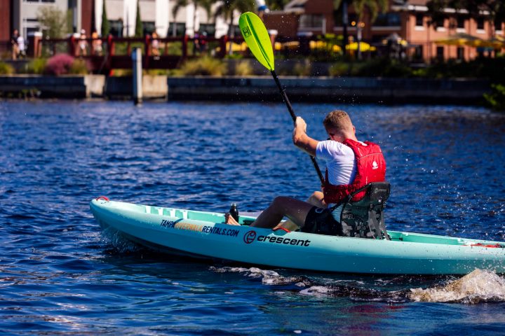a man riding on the back of a boat in the water