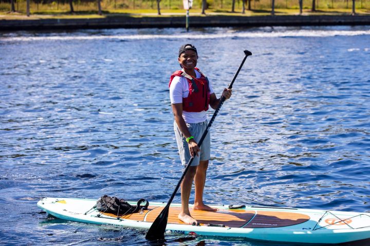 a man riding a paddle board on top of a body of water