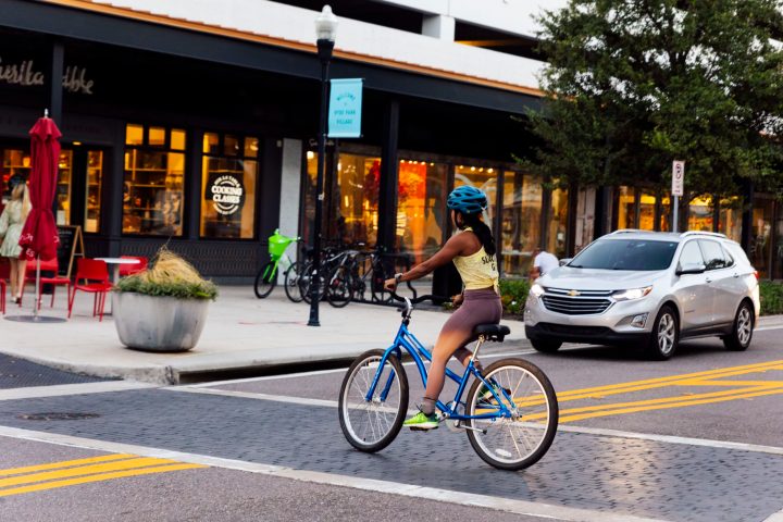 women crossing the street on a bike